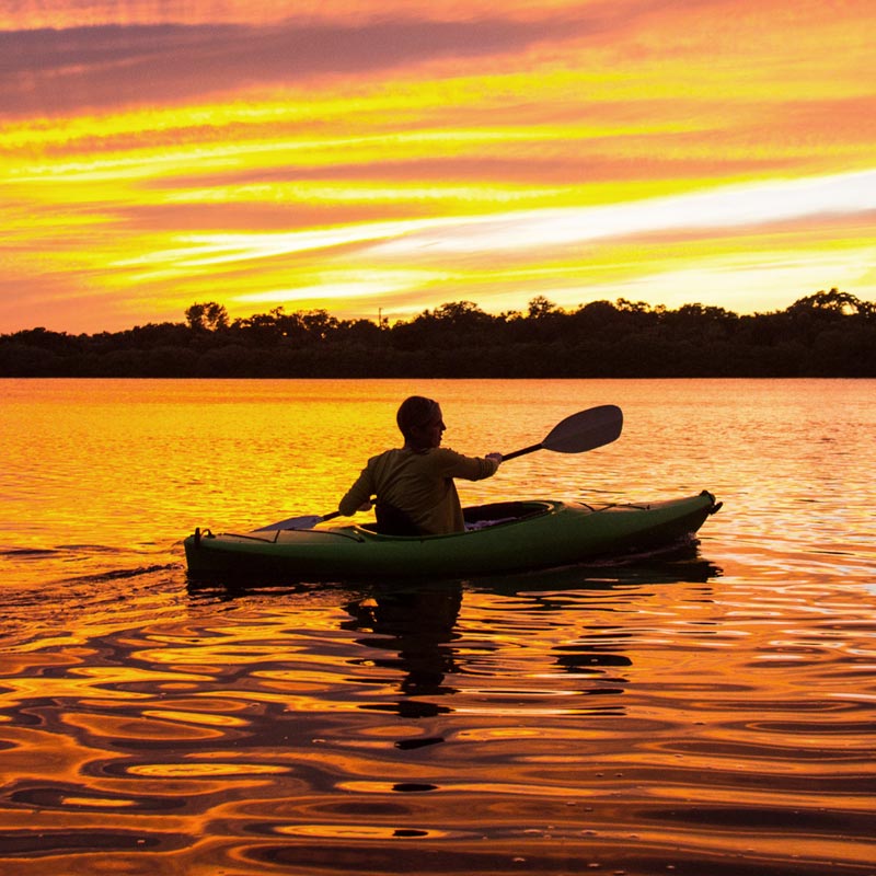 Man kayaking during sunset