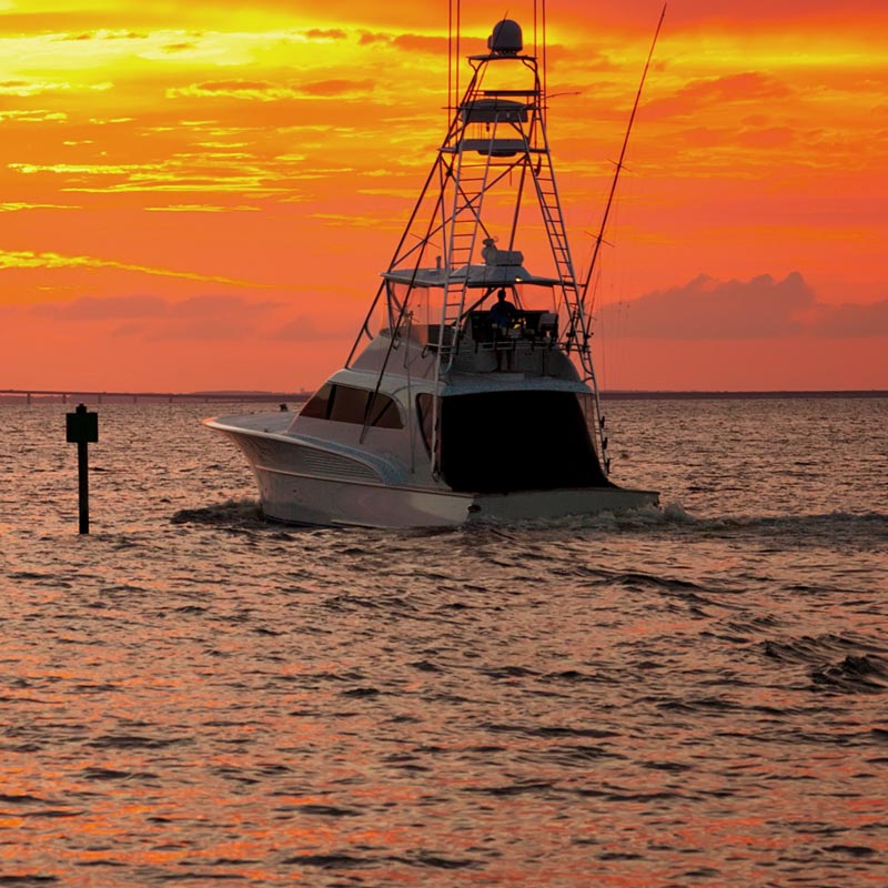 A fishing boat in the water during sunset